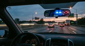 Carousel image 662f7810a35f54a881f7 driver view from front seat with blue lights in rear view mirror google gemini