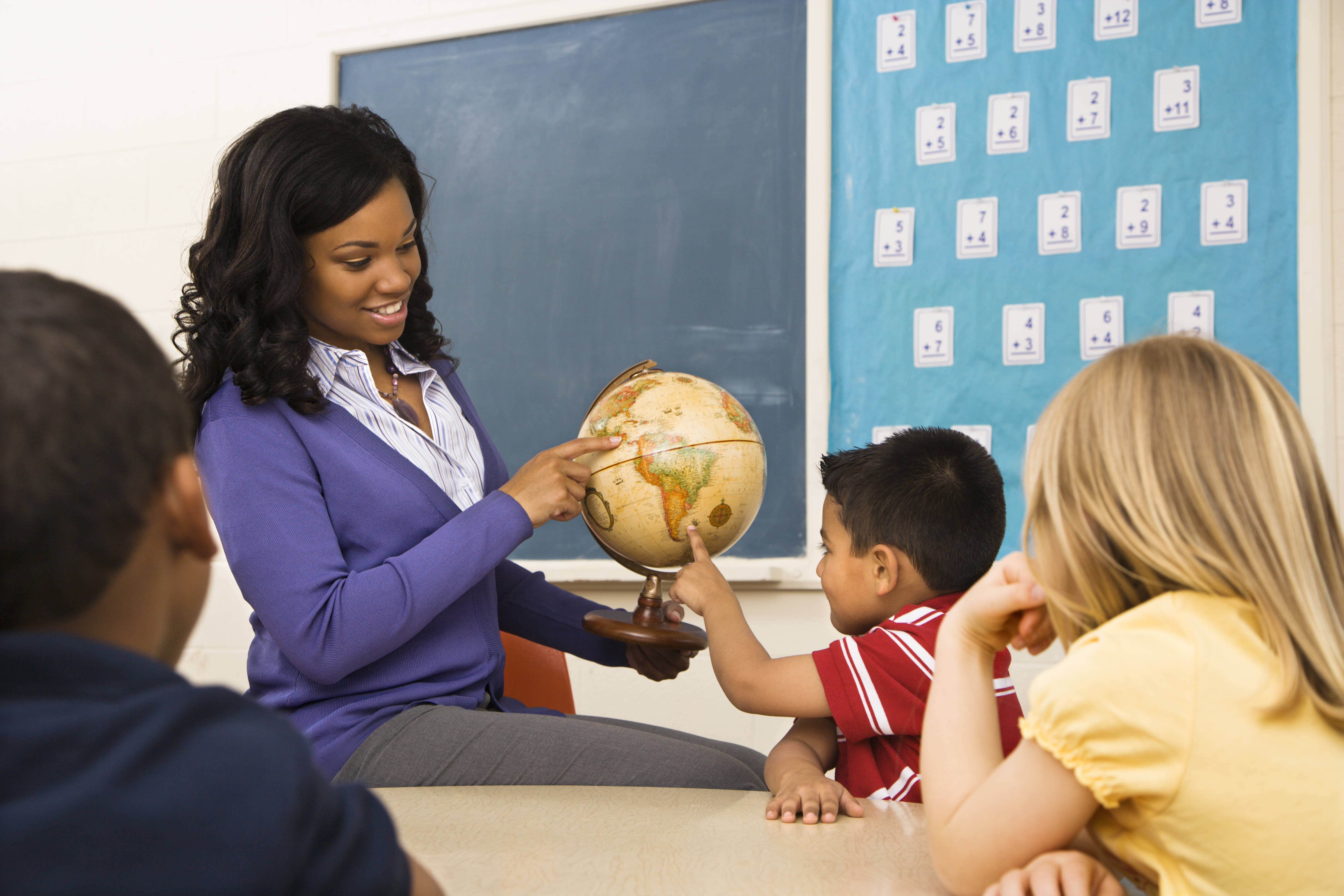 Carousel_image_cp_teacher_giving_geography_lesson_in_school_classroom_with_globe