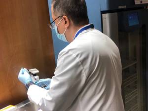 A healthcare professional at St. Joseph's Health prepares the COVID-19 vaccine for injection.